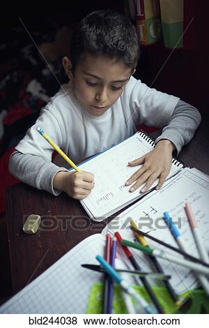 Stock Photo - Hispanic boy practicing writing alphabet. Fotosearch