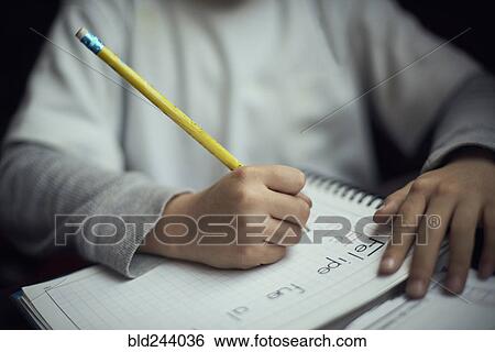 Stock Photograph - Hispanic boy practicing writing alphabet. Fotosearch