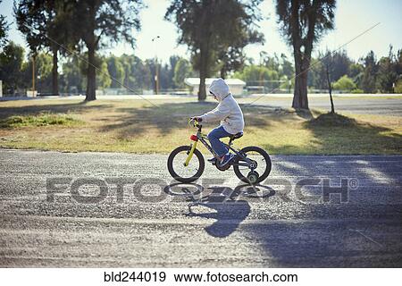 Hispanic boy riding bicycle with training wheels View Large Photo Image Stock Photo - Hispanic boy riding bicycle with training wheels. Fotosearch