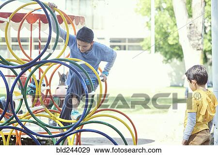 Hispanic boys climbing on structure at playground View Large Photo Image Stock Photo - Hispanic boys climbing on structure at playground. Fotosearch