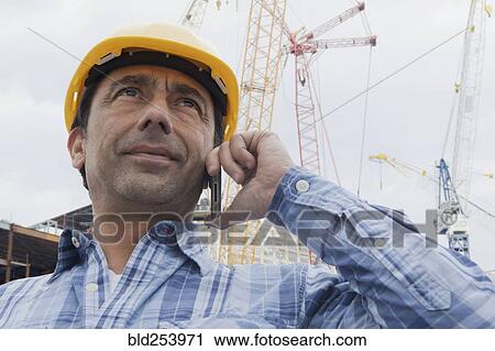 Hispanic construction worker talking on cell phone View Large Photo Image Stock Image - Hispanic construction worker talking on cell phone. Fotosearch