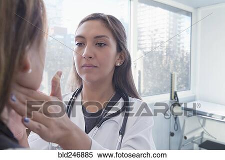 Hispanic doctor examining neck of patient View Large Photo Image Stock Photography - Hispanic doctor examining neck of patient. Fotosearch