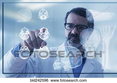 Stock Photograph - Hispanic doctor examining x-rays on virtual screen. Fotosearch