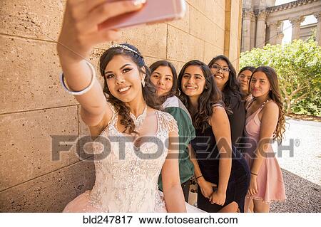 Stock Photo - Hispanic girls posing for cell phone selfie. Fotosearch