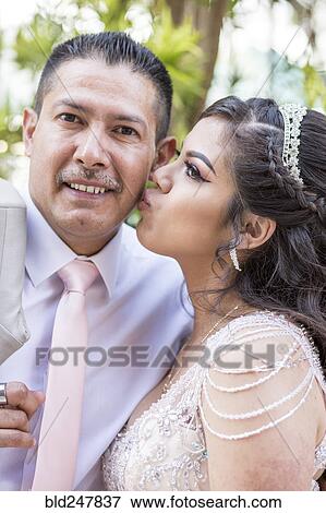 Hispanic girls wearing gown kissing father on cheek View Large Photo Image Stock Photo - Hispanic girls wearing gown kissing father on cheek. Fotosearch