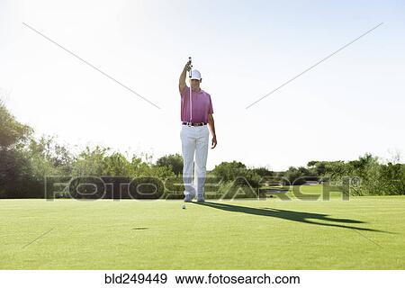 Stock Photo - Hispanic golfer aiming on golf course. Fotosearch