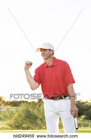 Stock Photo - Hispanic golfer celebrating on golf course. Fotosearch