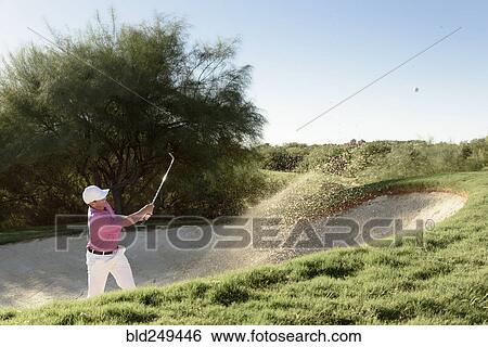 Hispanic golfer hitting ball in sand trap View Large Photo Image Stock Photograph - Hispanic golfer hitting ball in sand trap. Fotosearch