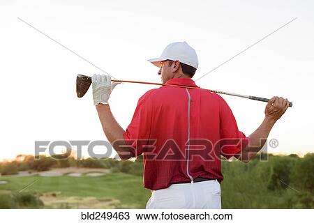 Stock Image - Hispanic golfer holding golf club on shoulders. Fotosearch