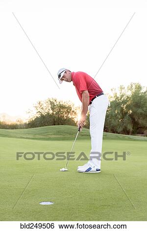 Hispanic golfer putting on golf course View Large Photo Image Stock Photograph - Hispanic golfer putting on golf course. Fotosearch