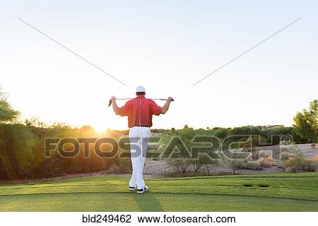 Stock Image - Hispanic golfer waiting on golf course. Fotosearch