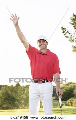 Stock Photo - Hispanic golfer waving on golf course. Fotosearch