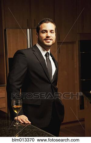 Hispanic man drinking wine in kitchen View Large Photo Image Stock Image - Hispanic man drinking wine in kitchen. Fotosearch