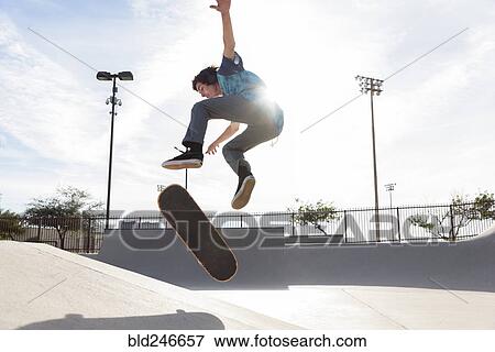 Hispanic man performing mid-air trick on skateboard View Large Photo Image Stock Photo - Hispanic man performing mid-air trick on skateboard. Fotosearch