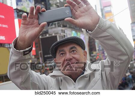 Hispanic man posing for cell phone selfie in city View Large Photo Image Stock Photography - Hispanic man posing for cell phone selfie in city. Fotosearch