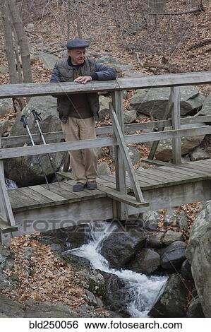Hispanic man relaxing on footbridge View Large Photo Image Stock Photograph - Hispanic man relaxing on footbridge. Fotosearch