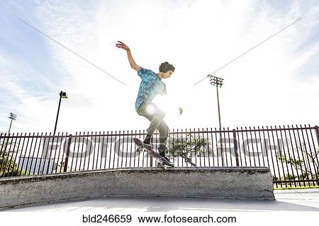 Stock Photo - Hispanic man riding skateboard in skate park. Fotosearch