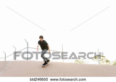 Stock Image - Hispanic man skateboarding in skate park. Fotosearch