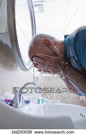 Hispanic man splashing water on face in bathroom View Large Photo Image Stock Photo - Hispanic man splashing water on face in bathroom. Fotosearch