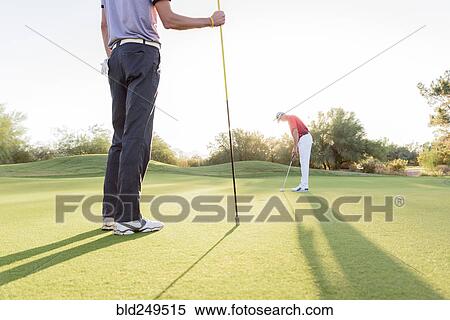 Hispanic man watching friend on golf course View Large Photo Image Stock Photography - Hispanic man watching friend on golf course. Fotosearch