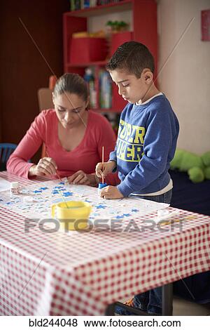 Hispanic mother and son painting stars at table View Large Photo Image Stock Photo - Hispanic mother and son painting stars at table. Fotosearch