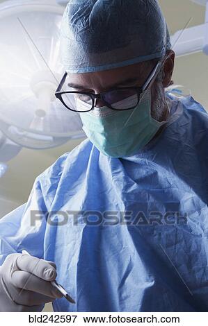 Stock Photo - Hispanic surgeon holding scalpel. Fotosearch