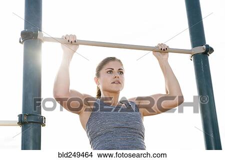 Hispanic woman doing chin-up outdoors View Large Photo Image Picture - Hispanic woman doing chin-up outdoors. Fotosearch