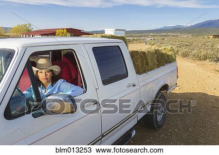 Stock Image - Hispanic woman driving truck. Fotosearch