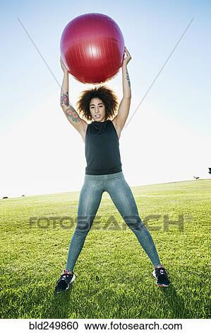 Hispanic woman exercising with fitness ball in sunny field View Large Photo Image Stock Image - Hispanic woman exercising with fitness ball in sunny field. Fotosearch