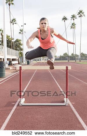 Hispanic woman jumping over hurdle View Large Photo Image Stock Image - Hispanic woman jumping over hurdle. Fotosearch