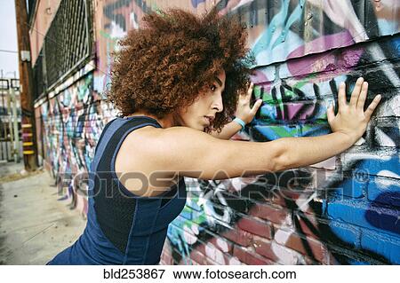 Hispanic woman leaning on graffiti wall View Large Photo Image Stock Photo - Hispanic woman leaning on graffiti wall. Fotosearch