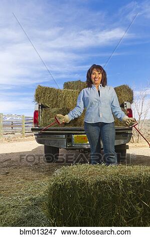 Hispanic woman loading hay onto truck View Large Photo Image Stock Photo - Hispanic woman loading hay onto truck. Fotosearch