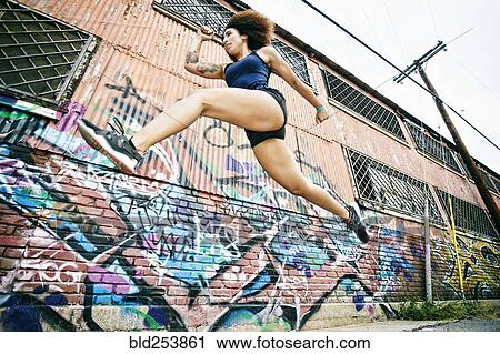 Hispanic woman running and jumping near graffiti wall View Large Photo Image Stock Image - Hispanic woman running and jumping near graffiti wall. Fotosearch