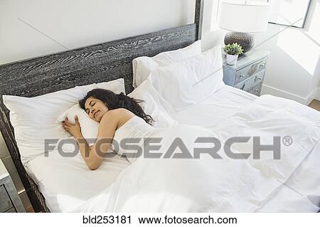Stock Image - Hispanic woman sleeping in bed. Fotosearch