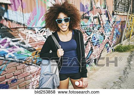 Hispanic woman standing near graffiti wall View Large Photo Image Stock Photo - Hispanic woman standing near graffiti wall. Fotosearch