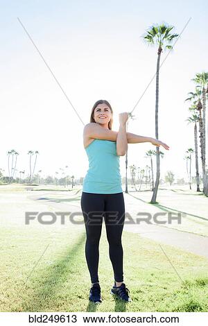 Stock Image - Hispanic woman stretching arm. Fotosearch