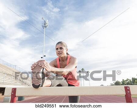 Hispanic woman stretching leg on hurdle View Large Photo Image Stock Image - Hispanic woman stretching leg on hurdle. Fotosearch