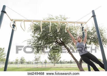 Hispanic woman swinging on monkey bars outdoors View Large Photo Image Stock Photo - Hispanic woman swinging on monkey bars outdoors. Fotosearch