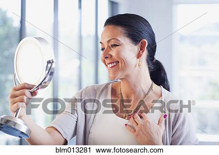 Hispanic woman trying on jewelry in store View Large Photo Image Stock Image - Hispanic woman trying on jewelry in store. Fotosearch