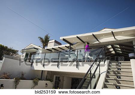 Hispanic woman walking on modern balcony View Large Photo Image Stock Photo - Hispanic woman walking on modern balcony. Fotosearch