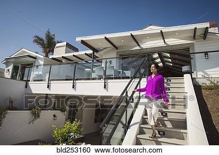 Hispanic woman walking on modern staircase View Large Photo Image Stock Image - Hispanic woman walking on modern staircase. Fotosearch