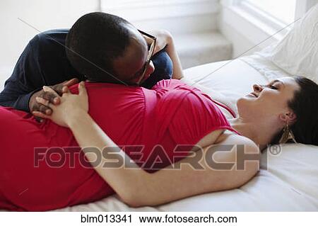 Husband laying on bed with pregnant wife View Large Photo Image Stock Image - Husband laying on bed with pregnant wife. Fotosearch