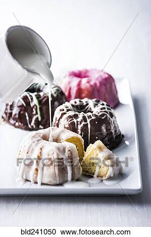 Icing pouring on miniature bundt cake View Large Photo Image Stock Image - Icing pouring on miniature bundt cake. Fotosearch
