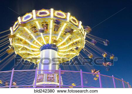 Illuminated spinning amusement park ride at night View Large Photo Image Stock Image - Illuminated spinning amusement park ride at night. Fotosearch