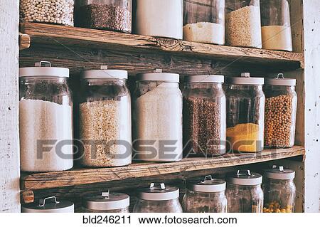 Stock Image - Jars of ingredients on wooden shelves. Fotosearch