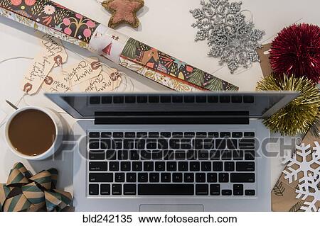 Stock Photography - Laptop, coffee, wrapping paper and Christmas ornaments. Fotosearch