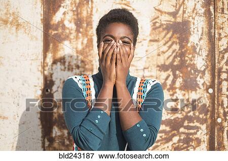 Stock Photo - Laughing African American woman with head in hands. Fotosearch