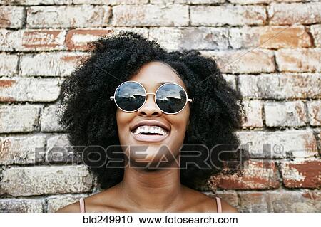 Laughing Black woman leaning on brick wall View Large Photo Image Stock Image - Laughing Black woman leaning on brick wall. Fotosearch