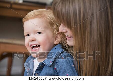 Stock Photo - Laughing Caucasian mother and daughter. Fotosearch