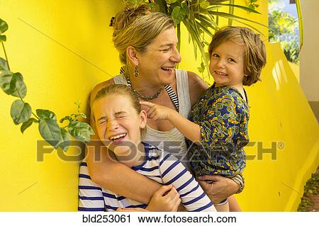 Laughing Caucasian mother hugging son and daughter View Large Photo Image Stock Image - Laughing Caucasian mother hugging son and daughter. Fotosearch